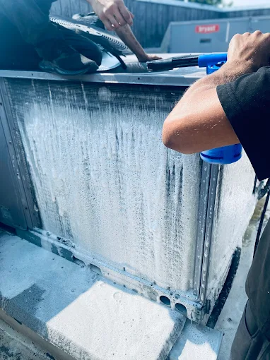 Techs cleaning an AC unit