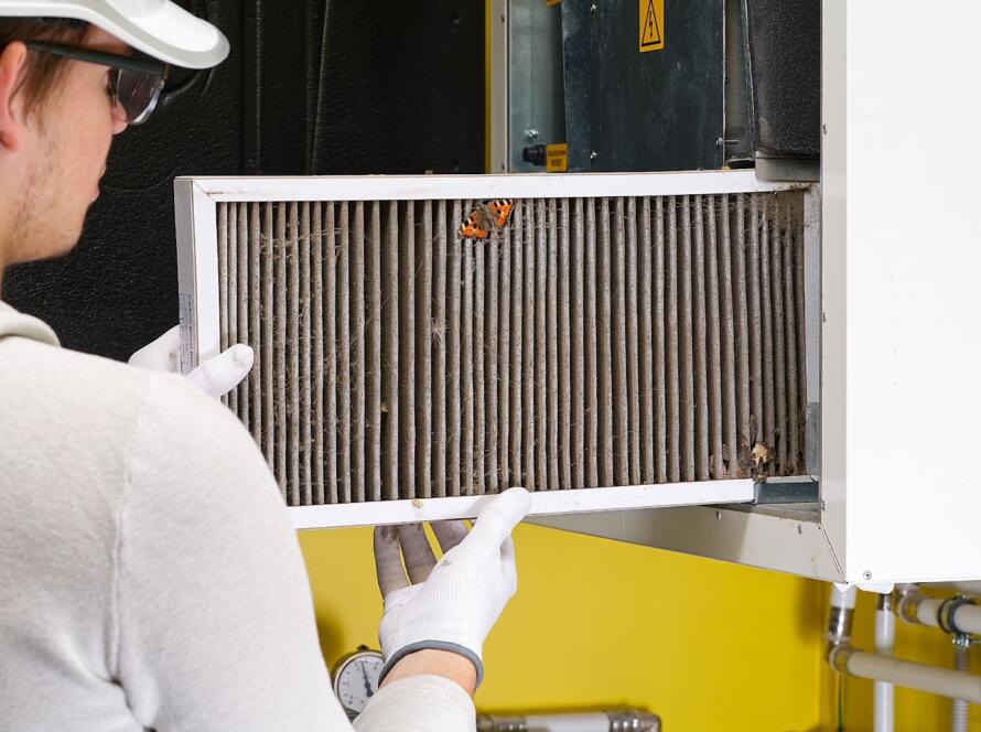 HVAC technician replacing air filter in residential central air system for cleaner airflow