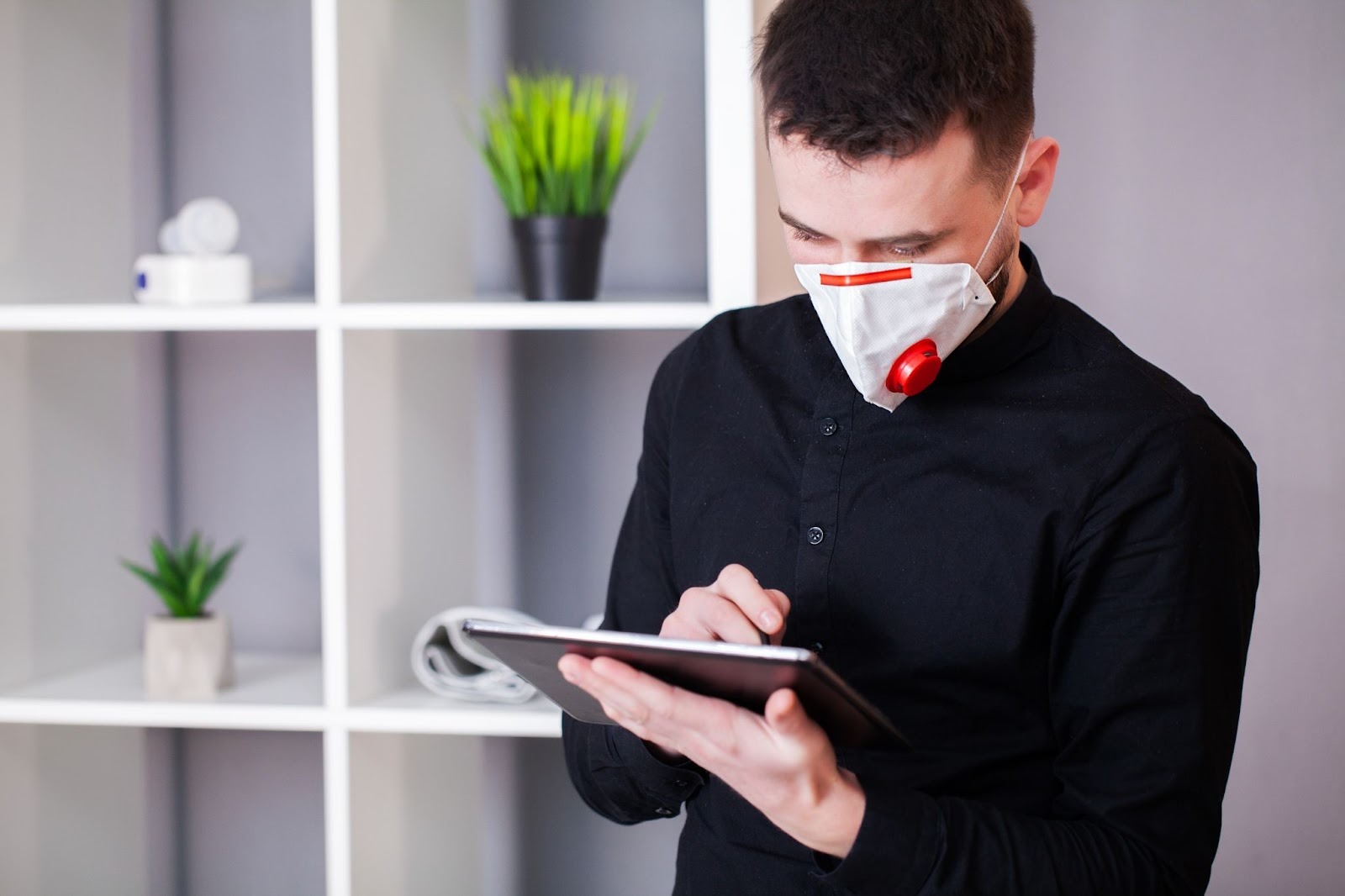 A specialist wearing a safety mask evaluates the air quality inside a residential space