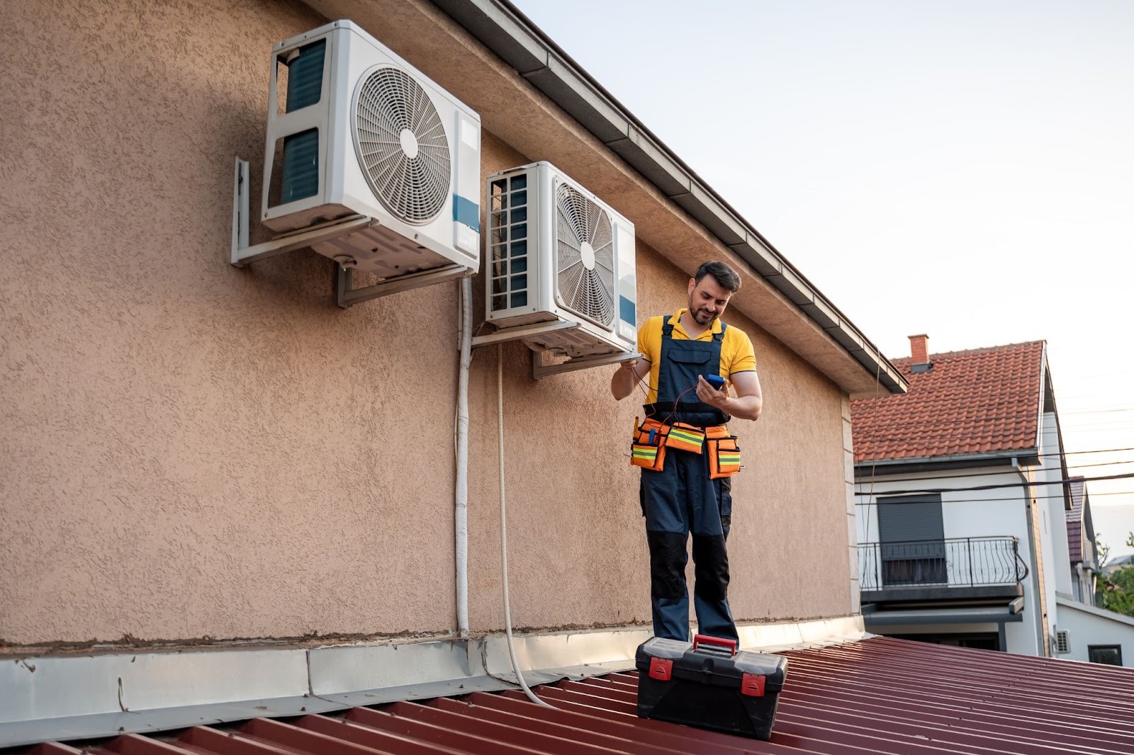 Service technician performing diagnostics on rooftop AC units at a residential property