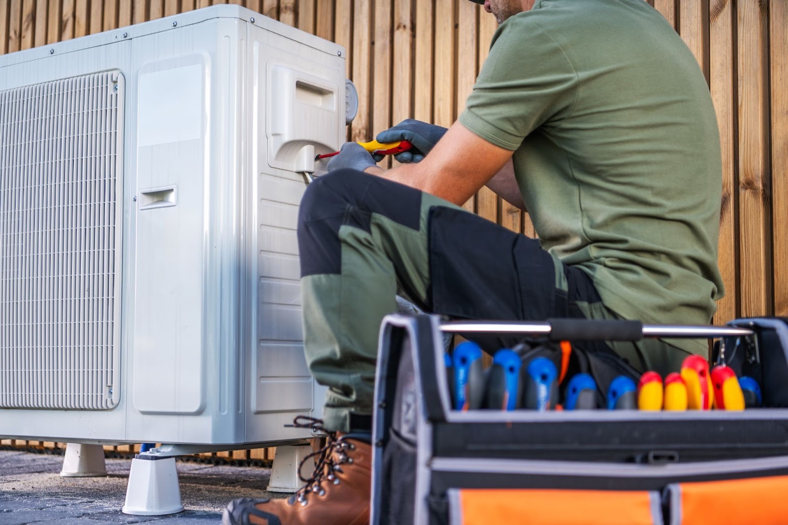 Technician conducting preventive maintenance on a home air conditioner outdoors